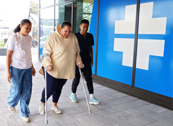 Woman on crutches going to appointment with children