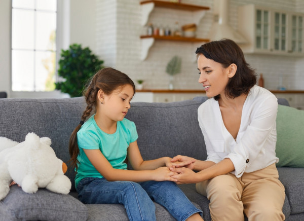 Woman talking to girl and holding her hand