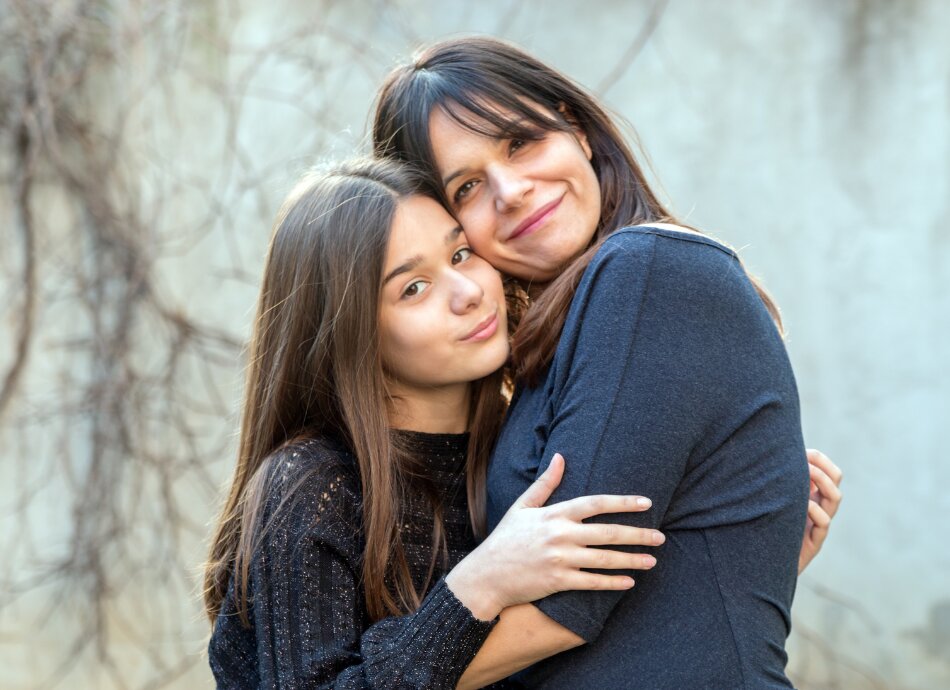 Mother and daughter hugging outside 