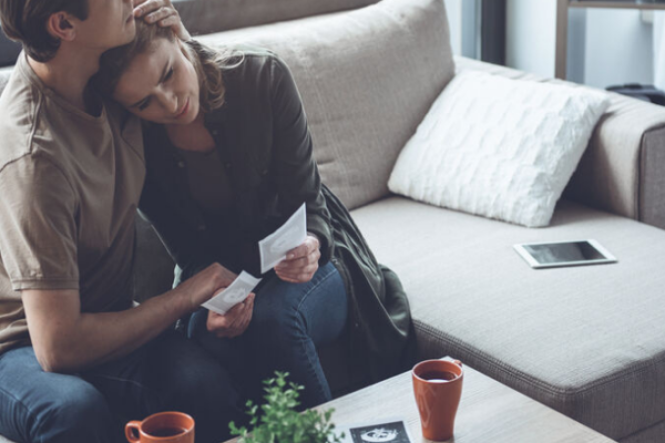 Sad couple looking at ultrasound picture after miscarriage
