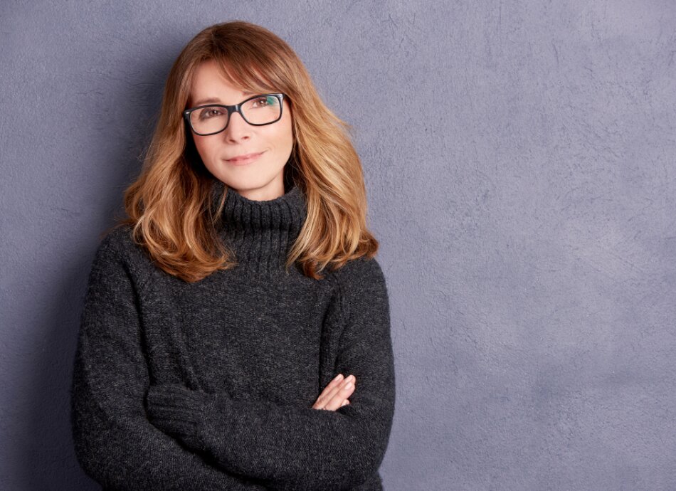 Confident woman wearing glasses with arms crossed