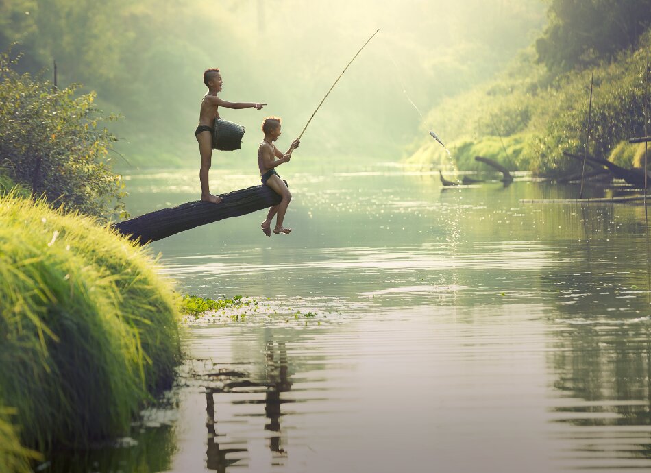 Boys catching fish in river Cambodia 