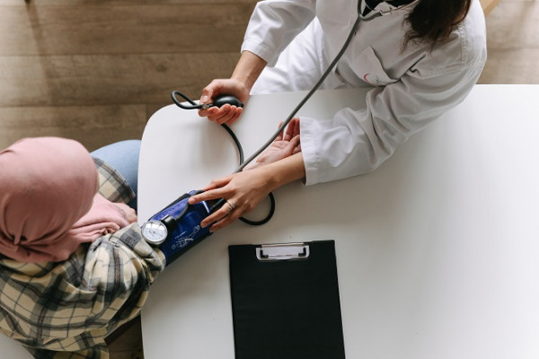 Aerial view female nurse or doctor does blood pressure check on man