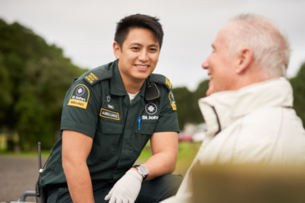 Ambulance paramedic talks to older man