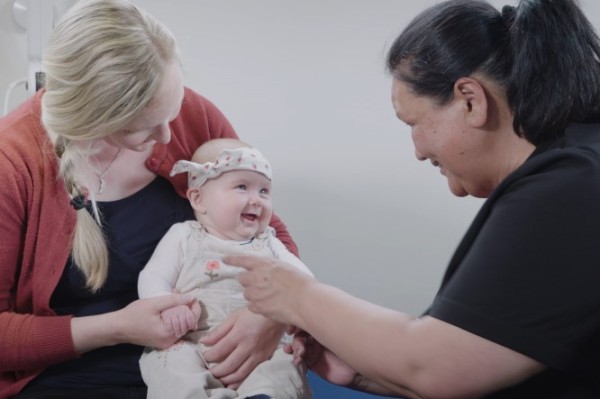 Nurse with mother and smiling baby