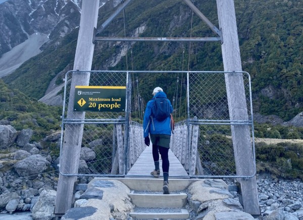 Man crosses a river bridge in NZ